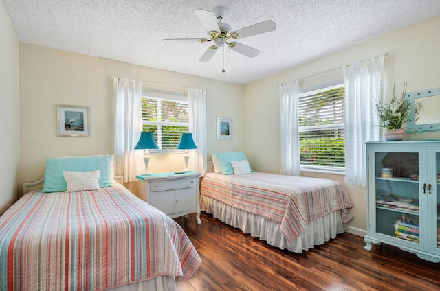 bedroom featuring multiple windows, dark wood-type flooring, and ceiling fan