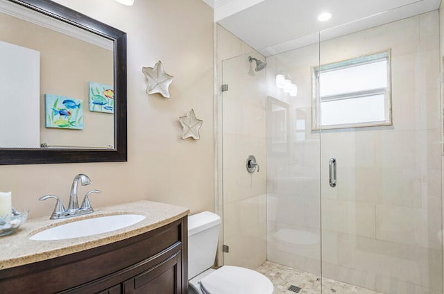 bathroom with walk in shower, vanity, and toilet