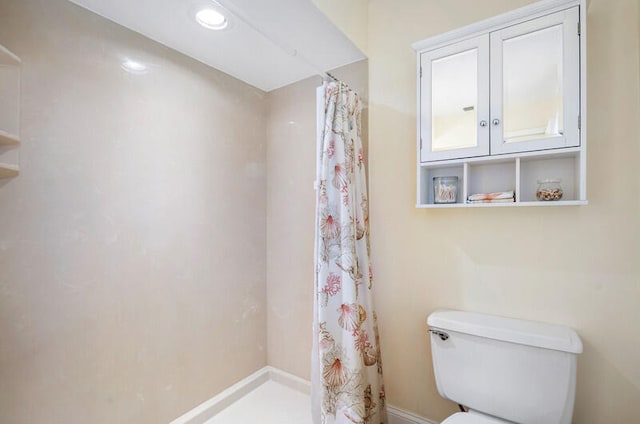 bathroom featuring a shower with shower curtain and toilet