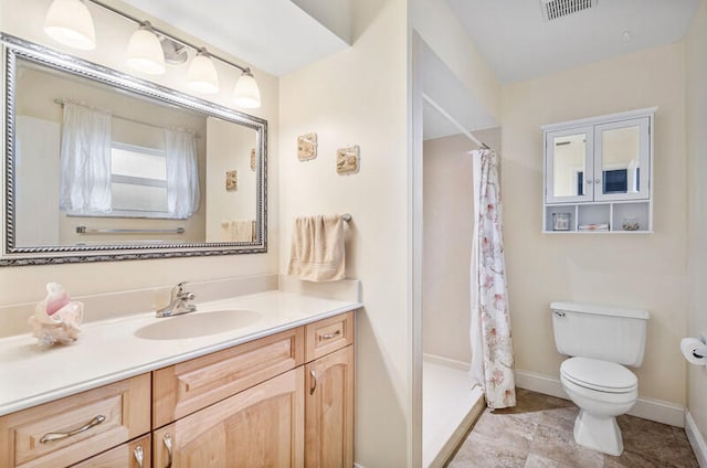 bathroom featuring vanity, toilet, and curtained shower