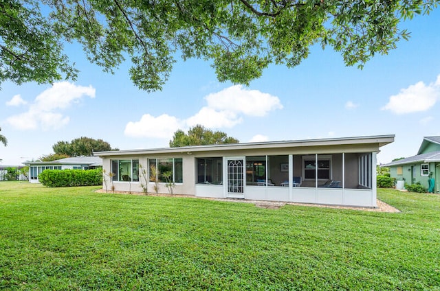 rear view of house with a sunroom and a yard