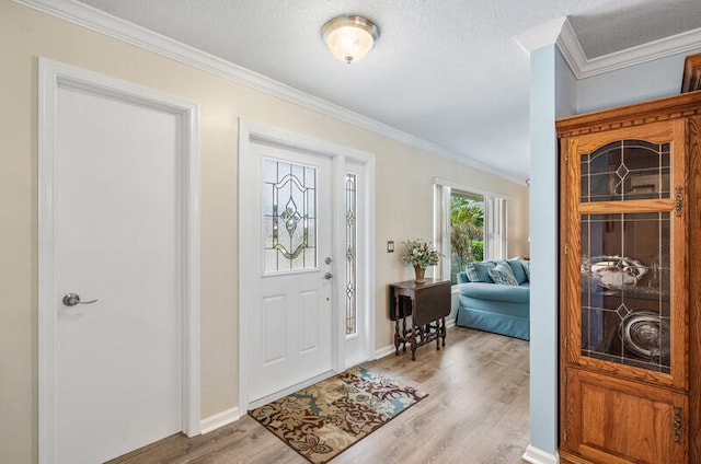 foyer entrance featuring a textured ceiling, light hardwood / wood-style flooring, and ornamental molding