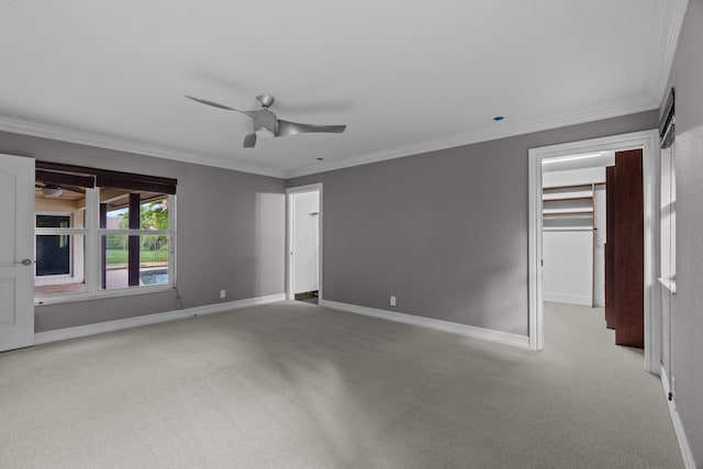 carpeted empty room with crown molding and ceiling fan