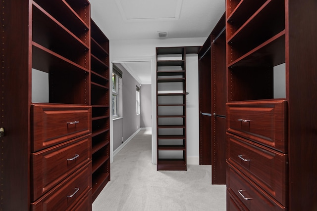 walk in closet featuring light colored carpet