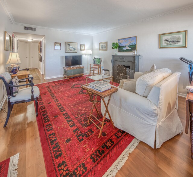 living room featuring hardwood / wood-style floors and crown molding