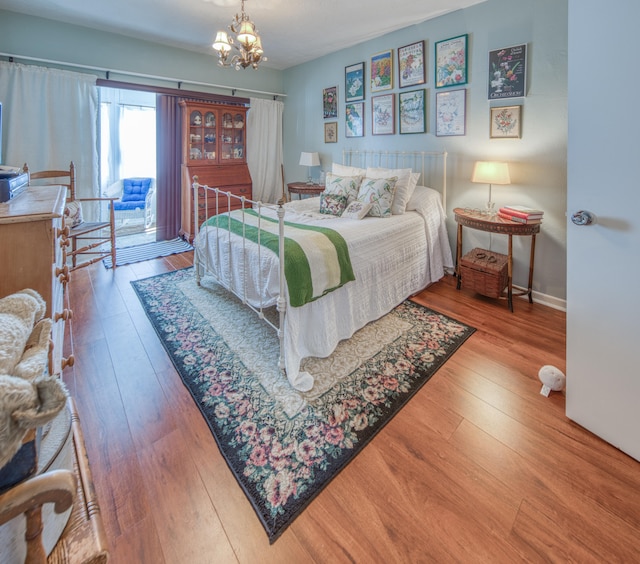 bedroom featuring a notable chandelier and wood-type flooring