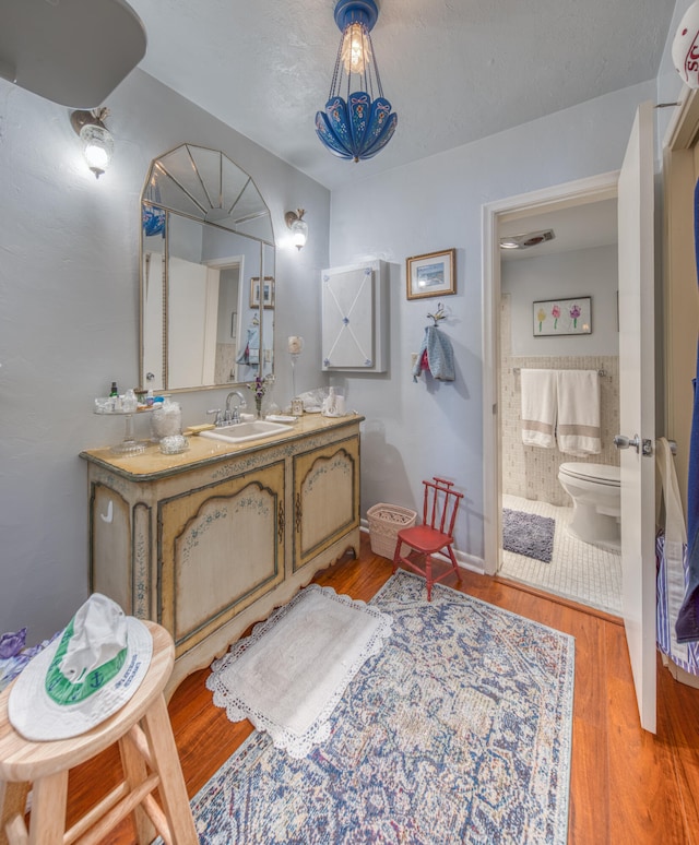 bathroom featuring vanity, wood-type flooring, and toilet