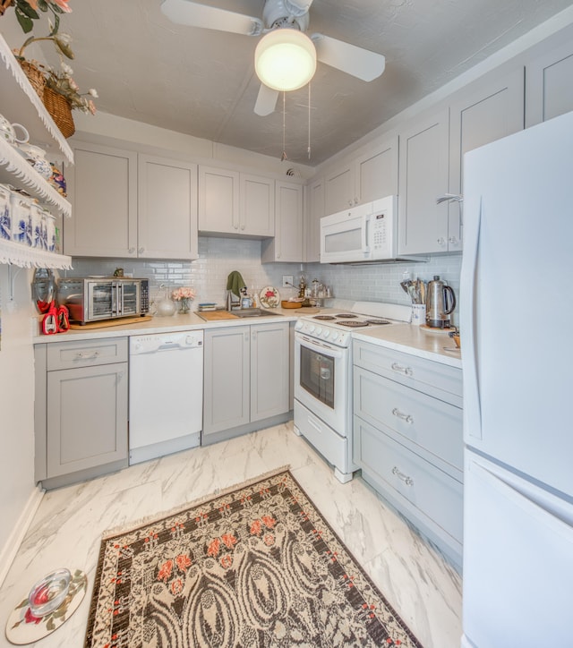 kitchen with tasteful backsplash, white appliances, ceiling fan, sink, and gray cabinets