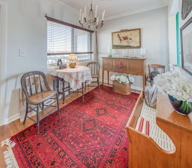 dining space with crown molding, hardwood / wood-style floors, and an inviting chandelier