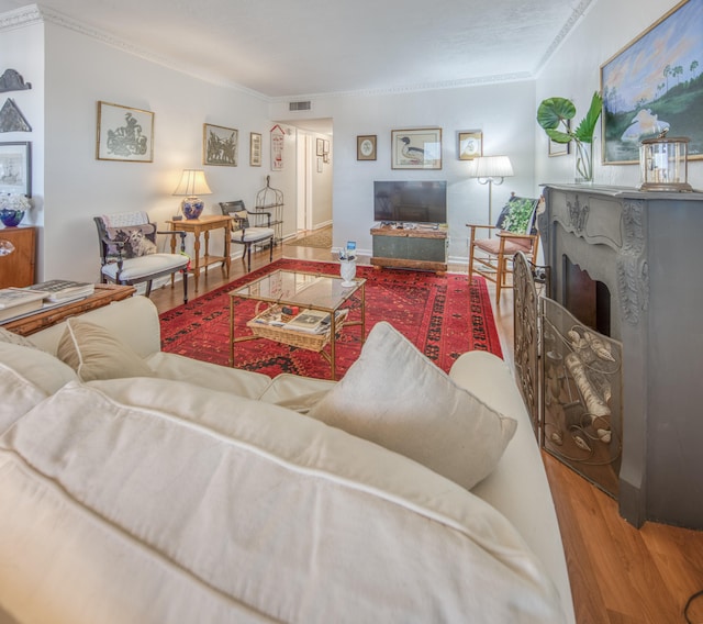 living room with wood-type flooring and ornamental molding