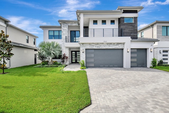 contemporary house featuring a garage, a balcony, a front yard, and french doors