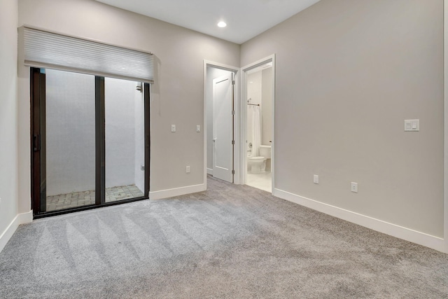 unfurnished bedroom featuring ensuite bathroom and carpet floors