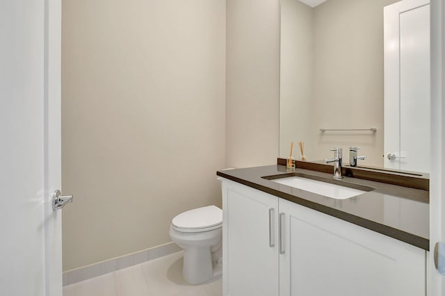 bathroom with tile patterned flooring, vanity, and toilet