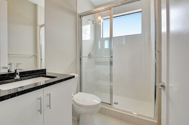 bathroom with tile patterned floors, vanity, toilet, and a shower with shower door