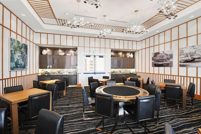 carpeted dining space featuring a high ceiling and a tray ceiling