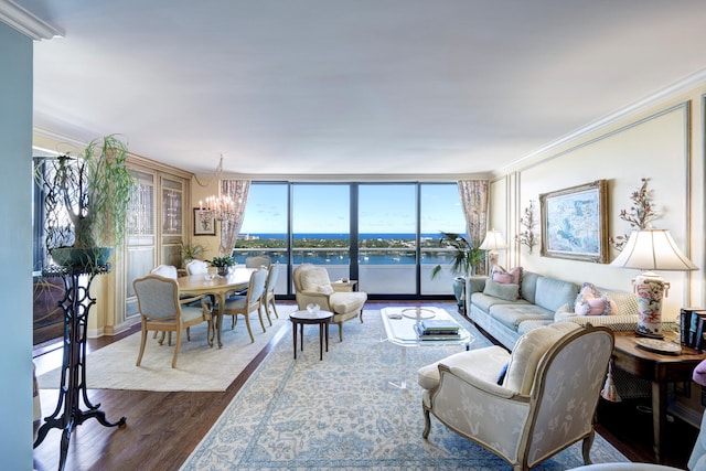 living room featuring ornamental molding, a water view, hardwood / wood-style flooring, a wall of windows, and a chandelier