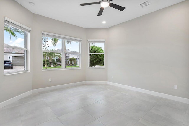 spare room with ceiling fan and light tile patterned flooring