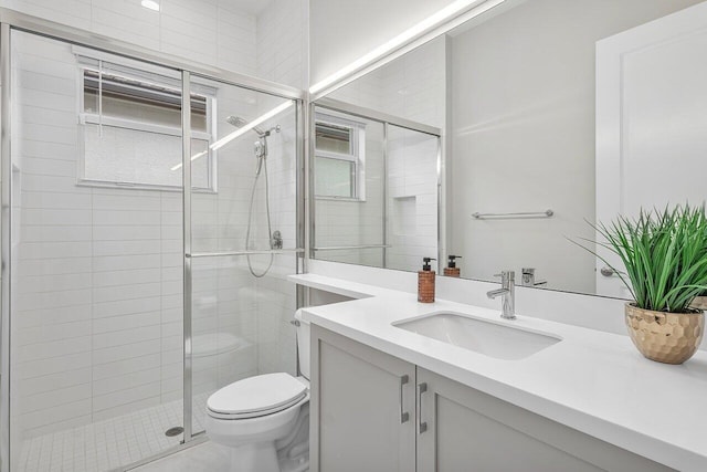 bathroom featuring toilet, vanity, and walk in shower