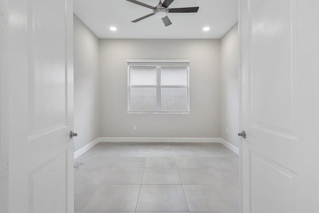 tiled spare room featuring ceiling fan