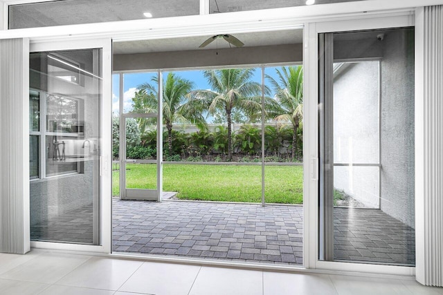 doorway to outside featuring ceiling fan and light tile patterned flooring