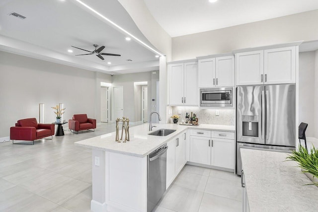 kitchen featuring sink, ceiling fan, appliances with stainless steel finishes, tasteful backsplash, and white cabinetry