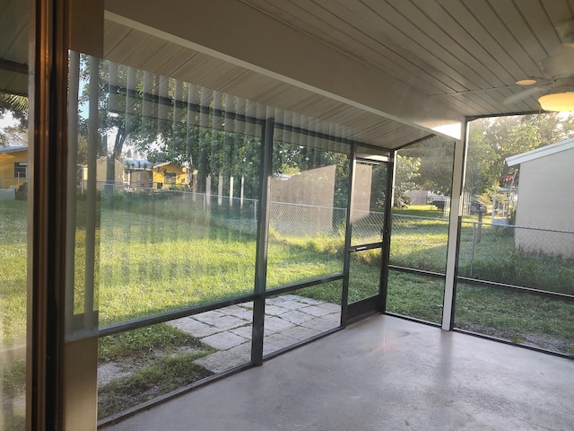 unfurnished sunroom featuring ceiling fan