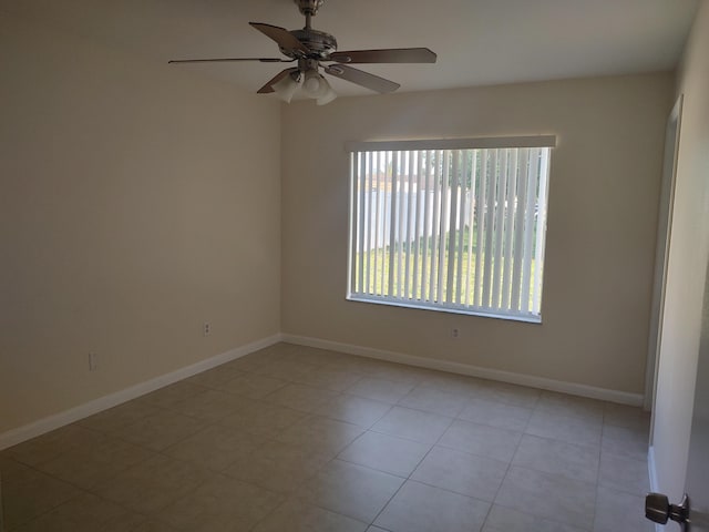 spare room with ceiling fan and light tile patterned flooring