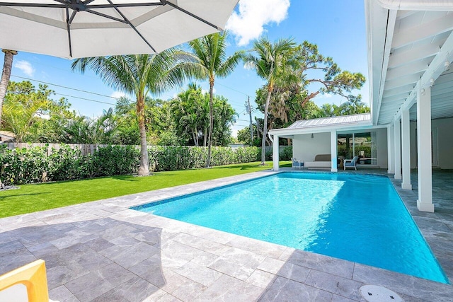 view of pool featuring a lawn and a patio area