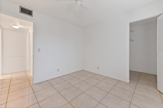 tiled spare room featuring ceiling fan and a textured ceiling