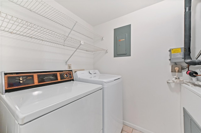 clothes washing area with light tile patterned floors, electric panel, and washer and dryer