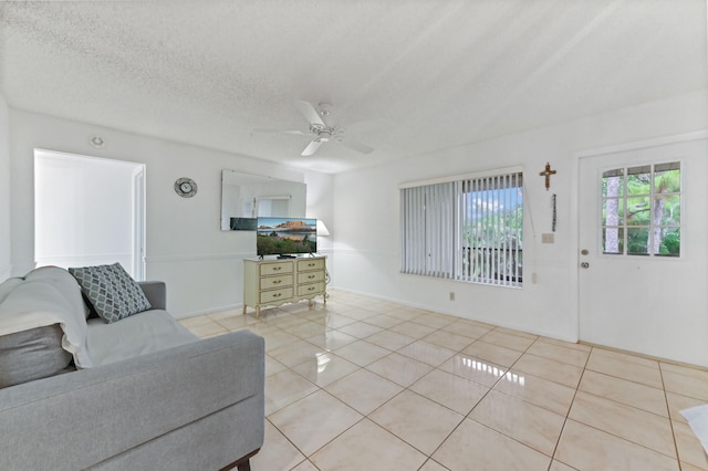 tiled living room featuring ceiling fan and a textured ceiling