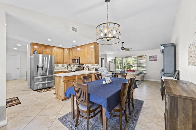 dining space with light tile patterned floors, visible vents, baseboards, vaulted ceiling, and ceiling fan with notable chandelier