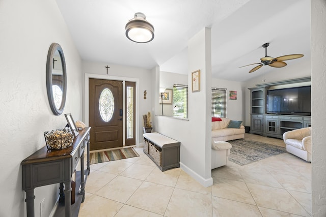 entryway with light tile patterned floors, ceiling fan, baseboards, and lofted ceiling