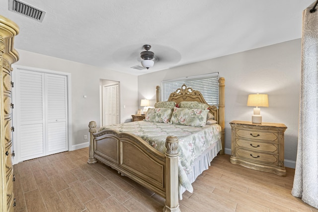 bedroom featuring ceiling fan, light wood-style floors, visible vents, and baseboards