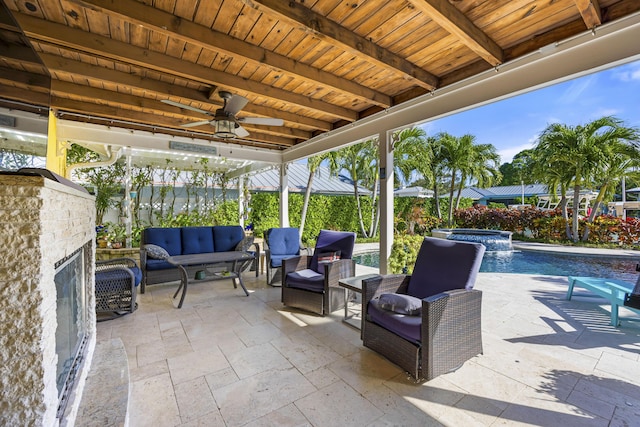 view of patio with an in ground hot tub and an outdoor living space with a fireplace