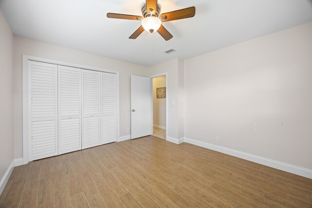 unfurnished bedroom with light wood-style floors, visible vents, a closet, and baseboards