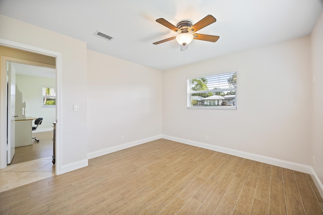 empty room featuring visible vents, baseboards, light wood-style floors, and a ceiling fan