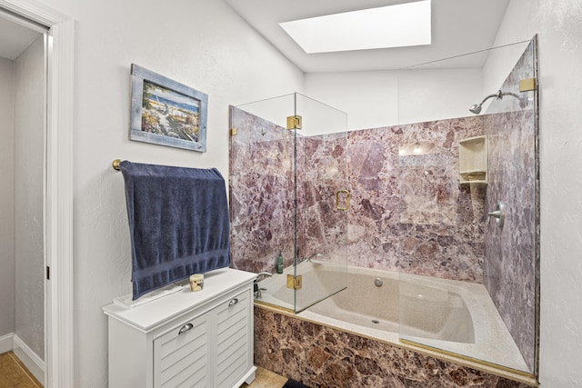 bathroom with a skylight and bath / shower combo with glass door