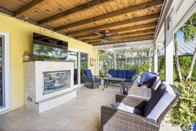 view of patio / terrace with an outdoor living space with a fireplace, a ceiling fan, and area for grilling