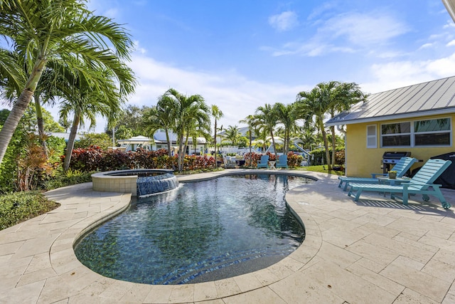 view of swimming pool with a patio and a pool with connected hot tub