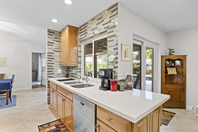 kitchen with light tile patterned floors, a sink, decorative backsplash, light countertops, and dishwasher