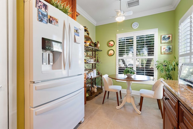 tiled dining room featuring ceiling fan and ornamental molding