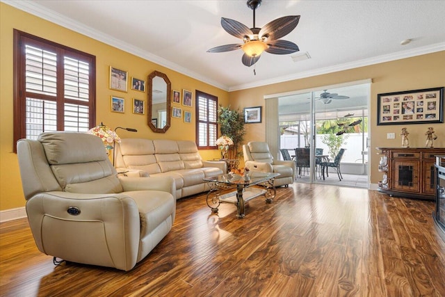 living room featuring ceiling fan, plenty of natural light, wood-type flooring, and ornamental molding