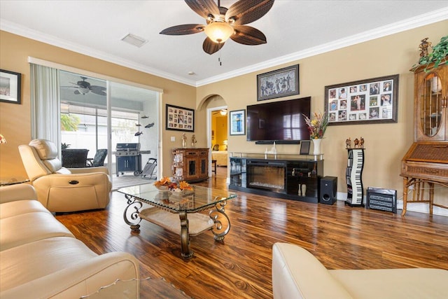 living room featuring a fireplace, hardwood / wood-style flooring, ceiling fan, and ornamental molding