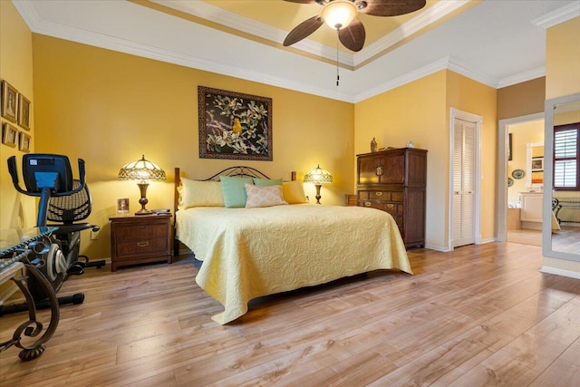 bedroom with ensuite bath, ceiling fan, ornamental molding, a closet, and light wood-type flooring