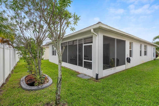 back of house featuring a sunroom and a yard