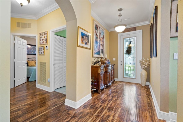 entrance foyer featuring crown molding, plenty of natural light, and dark wood-type flooring