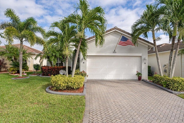 mediterranean / spanish-style house with a garage and a front lawn