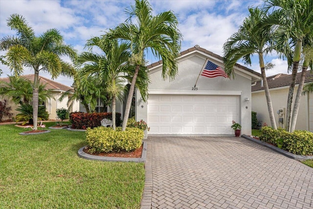 225 SW Coconut Key Way, Port Saint Lucie, FL 34986 - view of front facade with stucco siding, decorative driveway, a garage, and a front yard