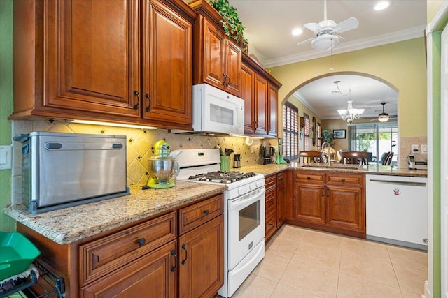 kitchen featuring sink, white appliances, decorative backsplash, light tile patterned floors, and ornamental molding